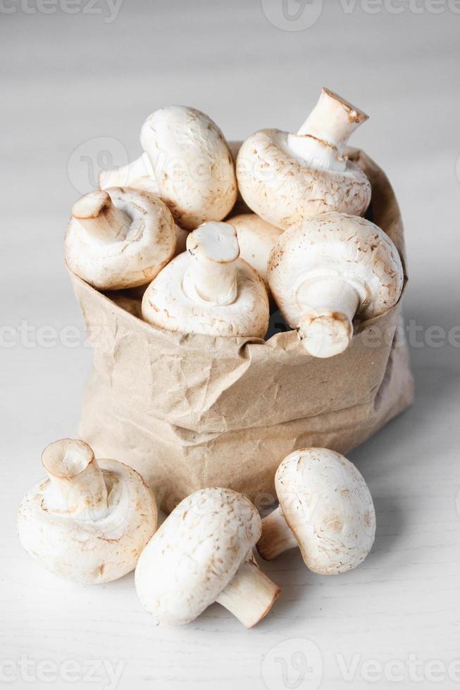 champignons champignons in papieren zak op een witte houten tafel foto