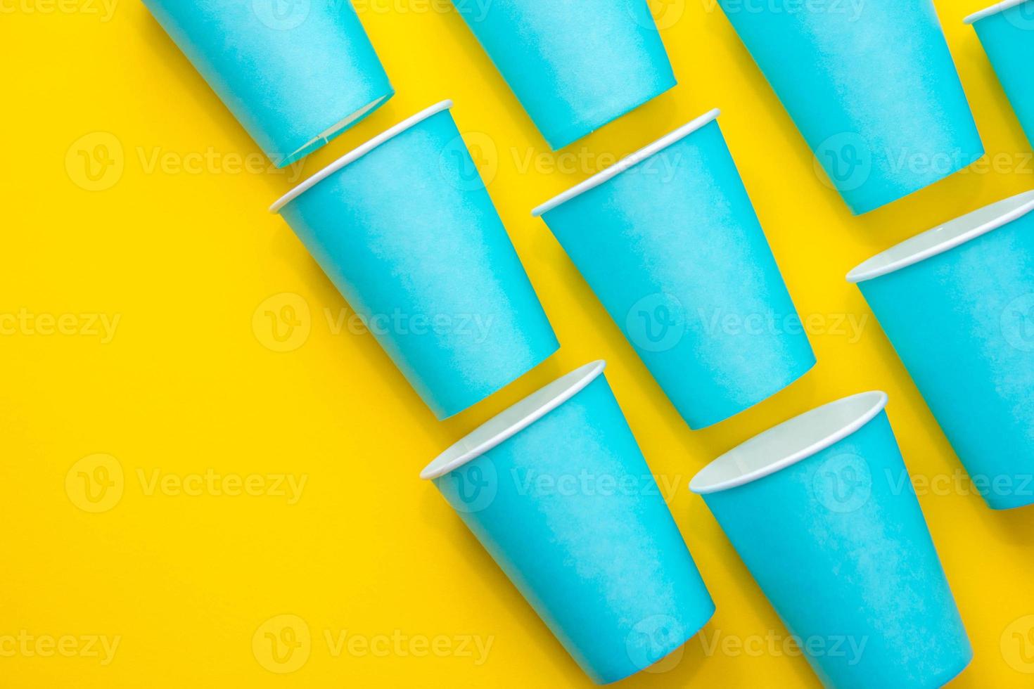 patroon van blauwe papieren wegwerpbekers op gele achtergrond foto