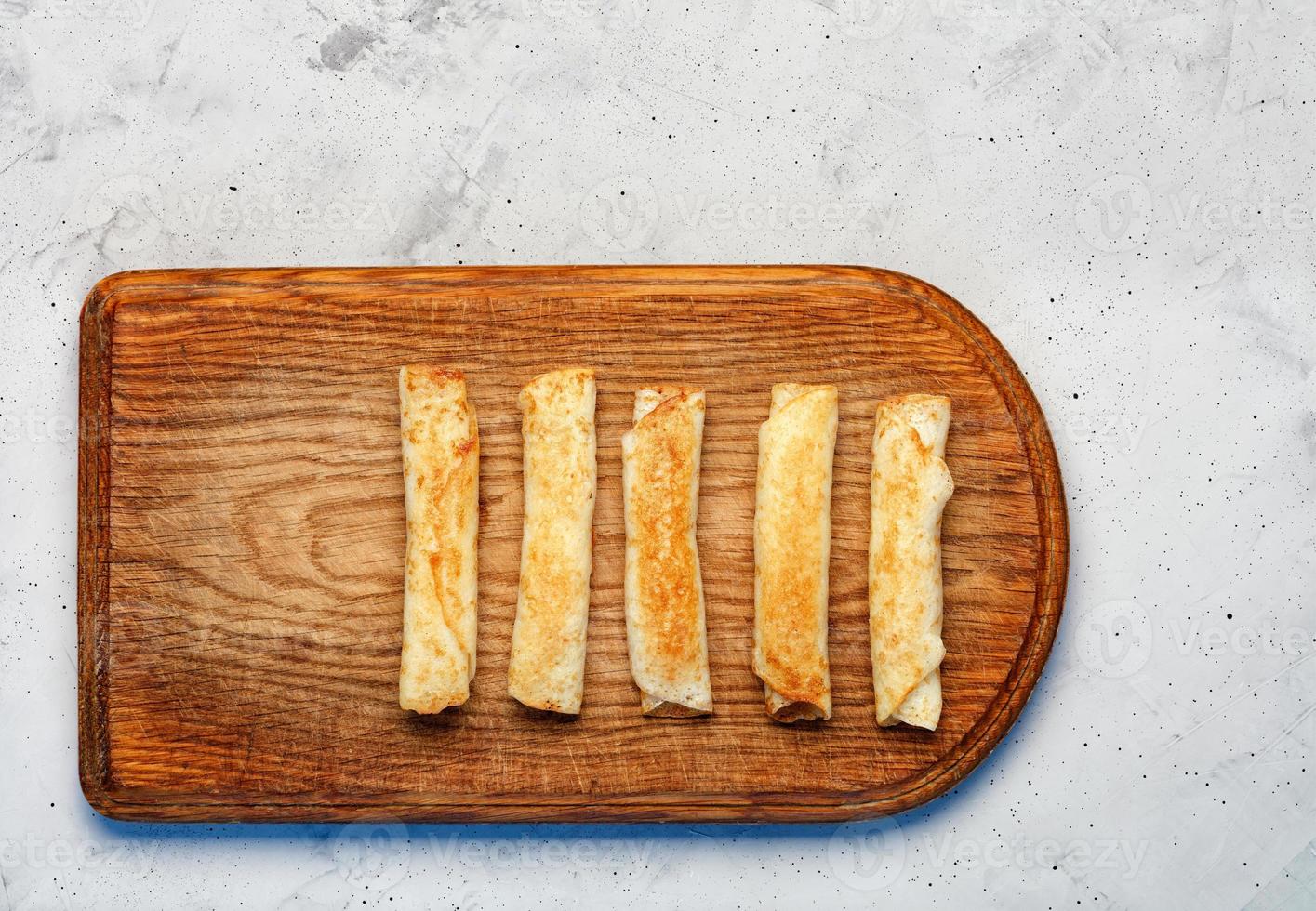 pannenkoeken met kwark op oude houten snijplank. foto