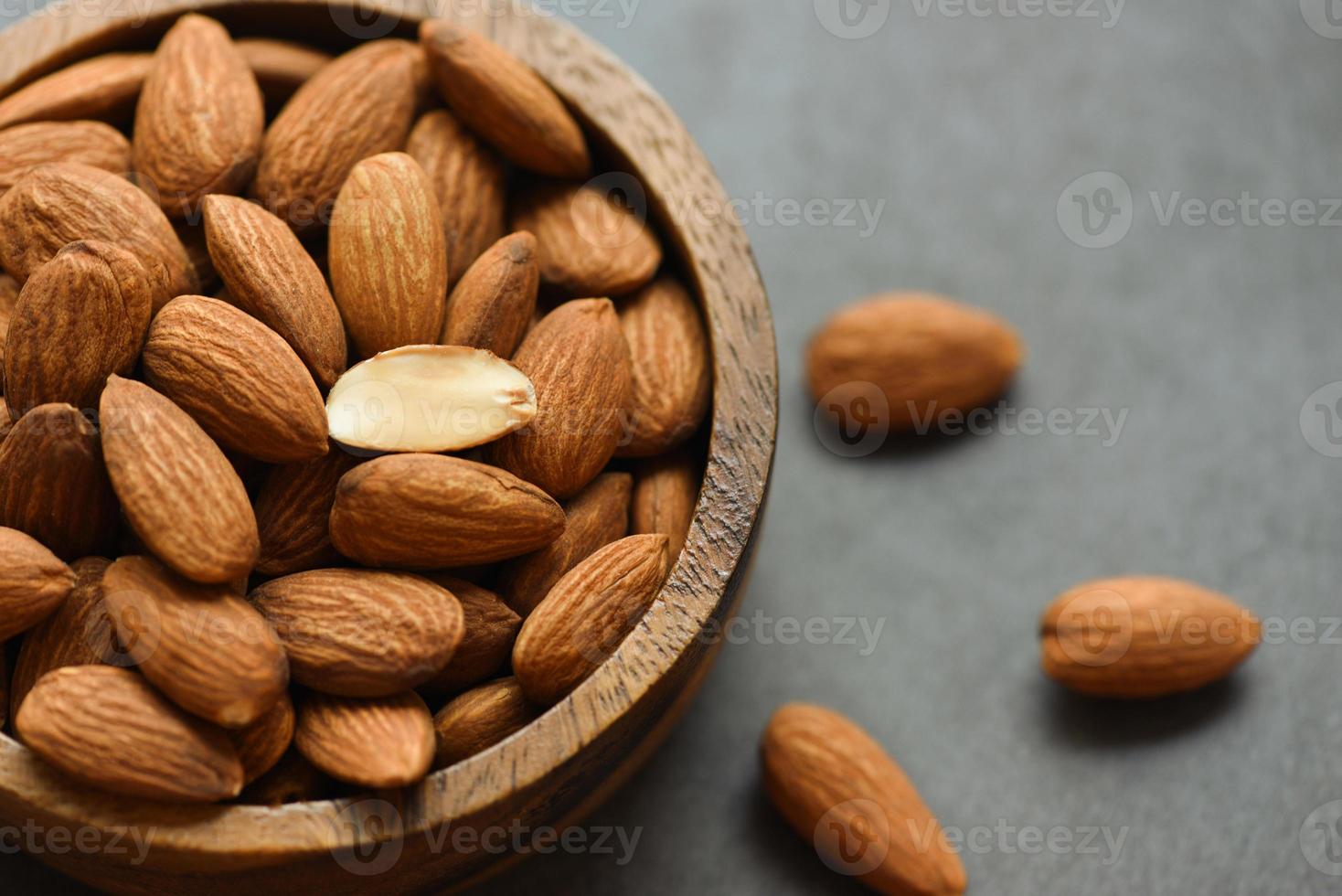 amandelen noten op houten schaal, close-up geroosterde amandelnoten natuurlijk eiwitvoedsel en voor een snack foto