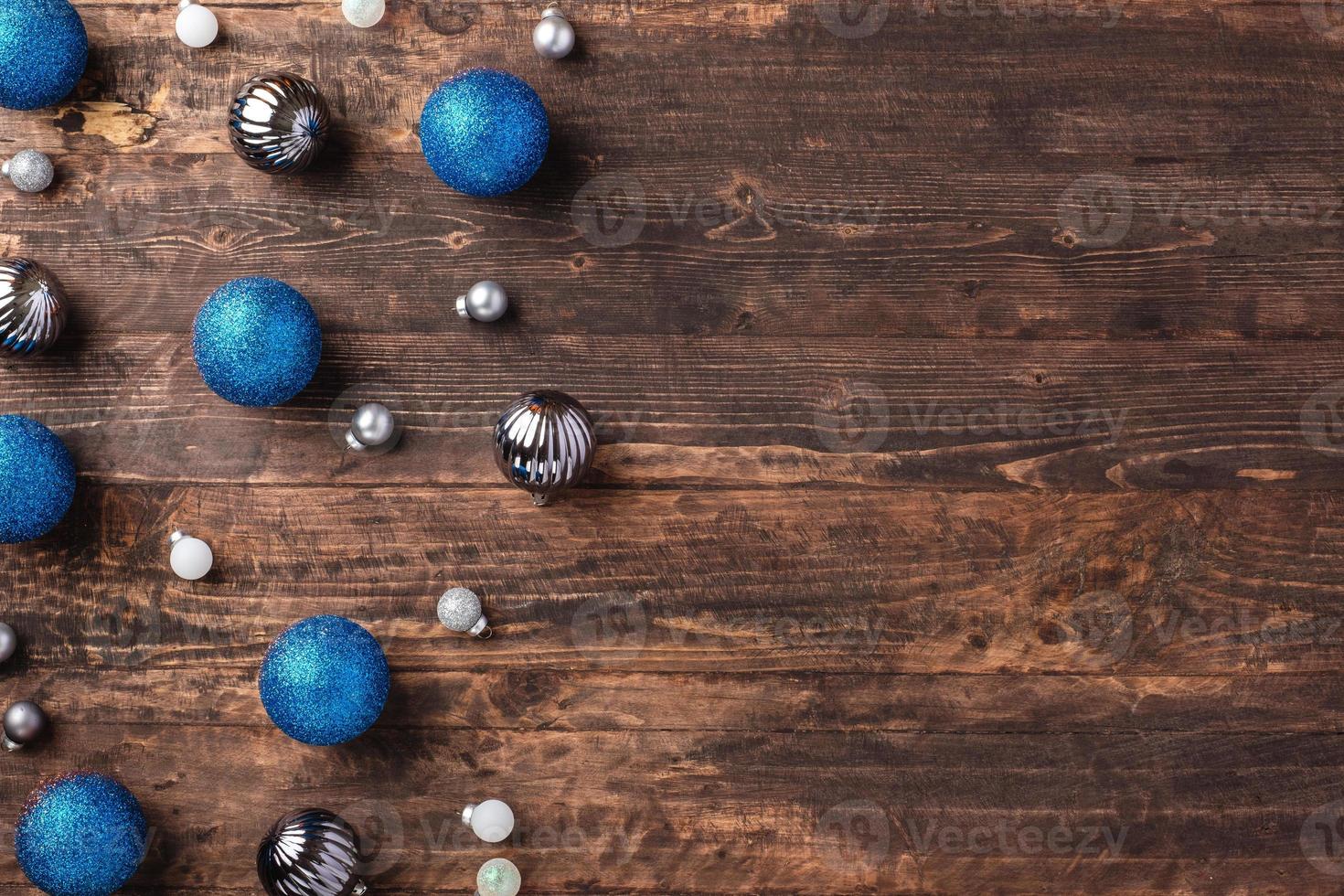 Kerst blauwe geschenkdoos en zilveren snuisterij decoratie ornament op houten tafel achtergrond foto