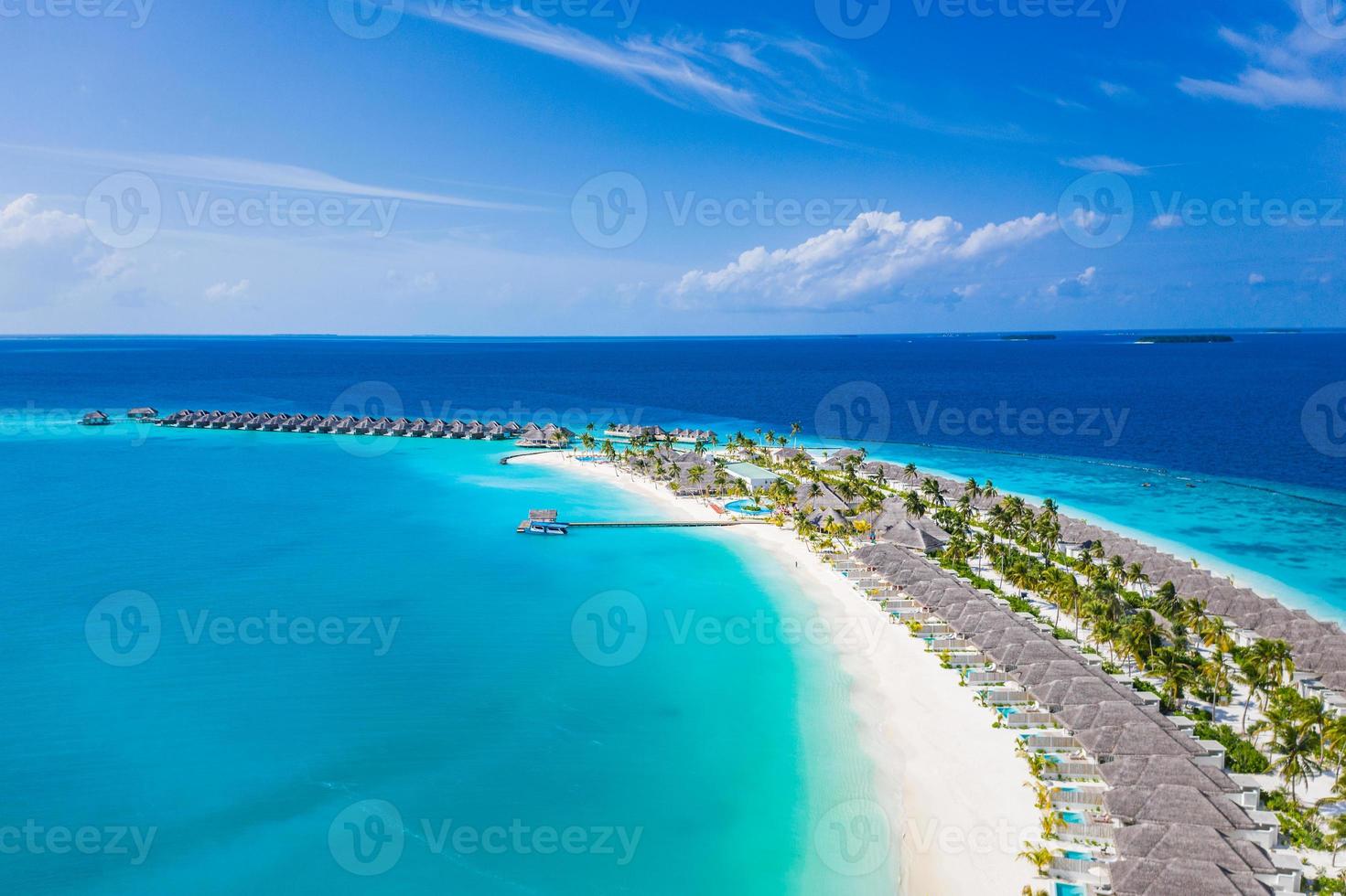 luchtfoto van het eiland maldiven, luxe watervilla's resort en houten pier. prachtige lucht en oceaan lagune strand. zomervakantie vakantie en reizen concept. paradijs luchtlandschap panorama foto