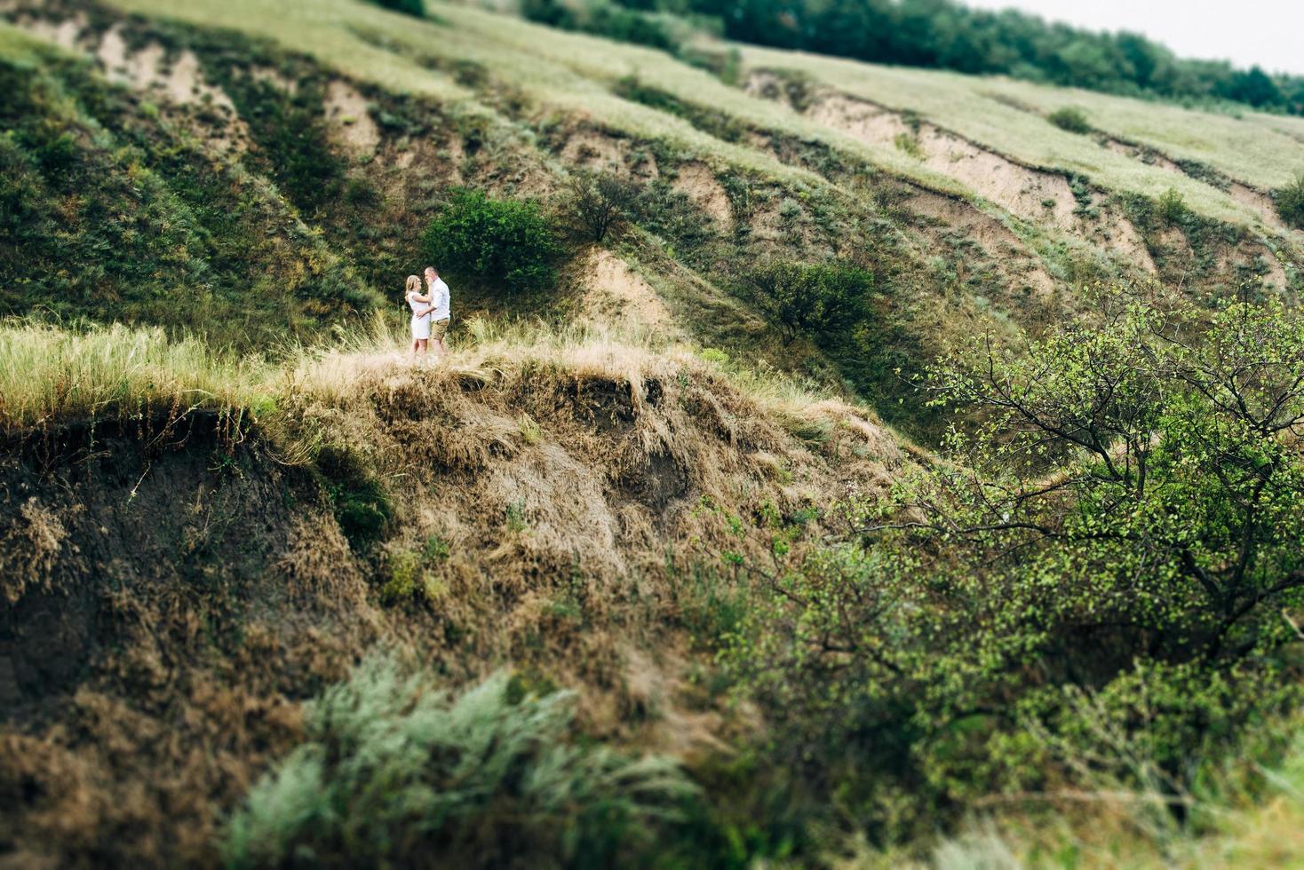 een man met een meisje in lichte kleding op de achtergrond van een groene canyon foto