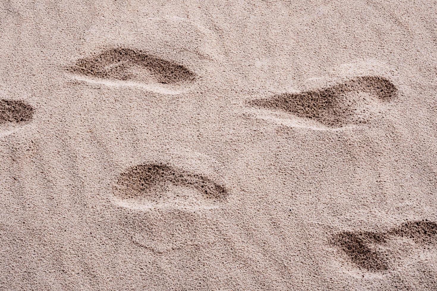 kuilen op zand, veroorzaakt door de voetafdruk van mensen foto