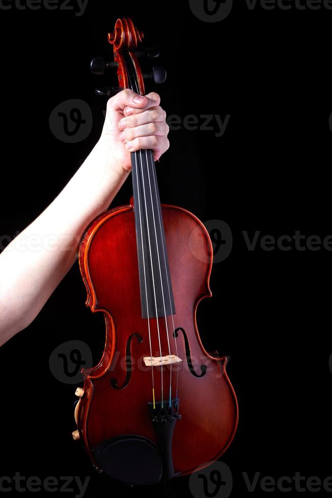 hand met een viool op een zwarte achtergrond, close-up. muziek concept. details van de viool foto