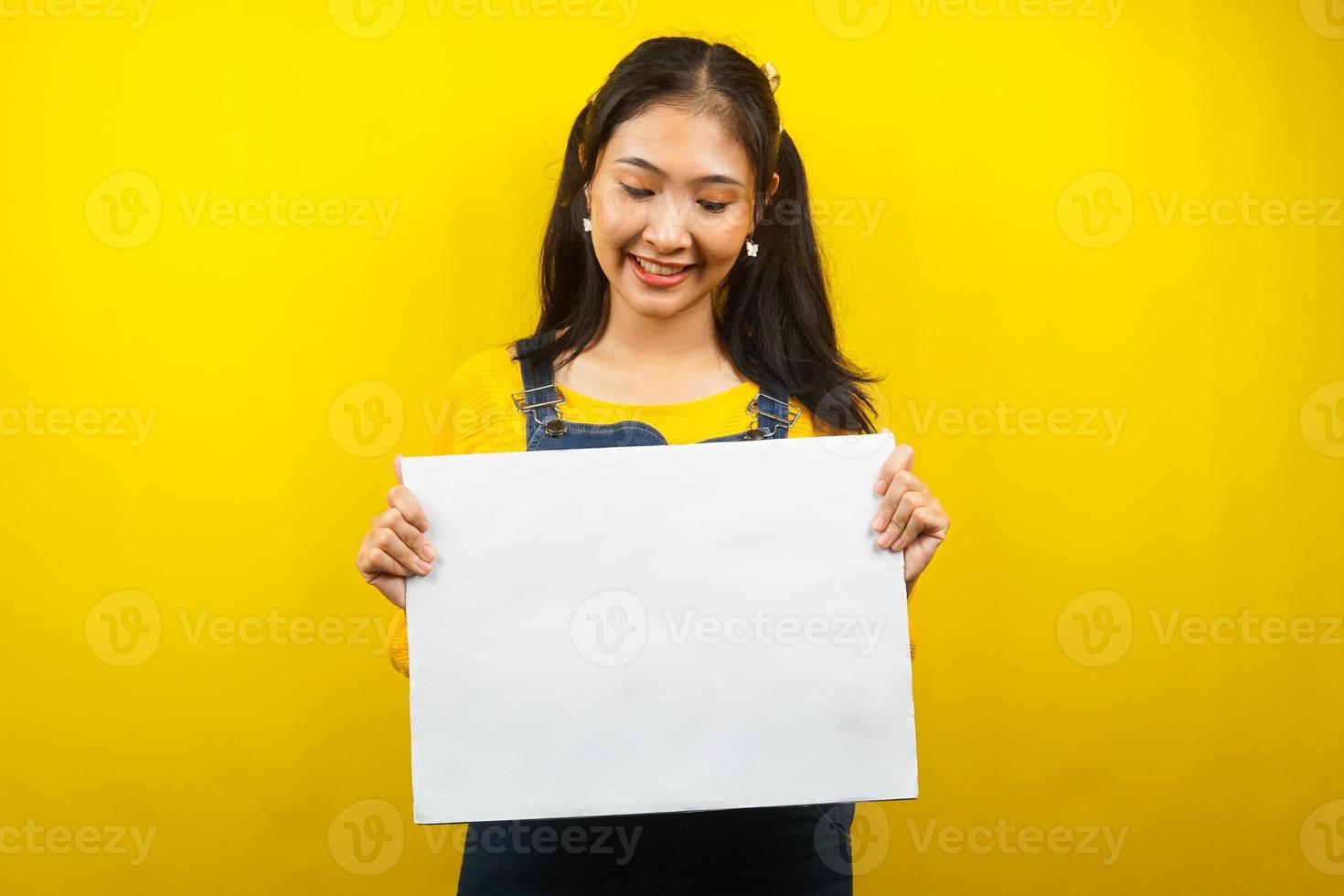 mooie en schattige jonge vrouw vrolijk met lege lege banner, plakkaat, wit bord, leeg bord, wit reclamebord, iets presenteren in kopieerruimte, promotie foto