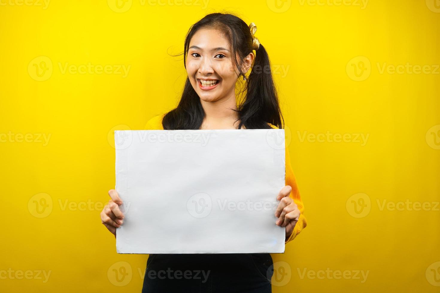 mooie en schattige jonge vrouw vrolijk met lege lege banner, plakkaat, wit bord, leeg bord, wit reclamebord, iets presenteren in kopieerruimte, promotie foto