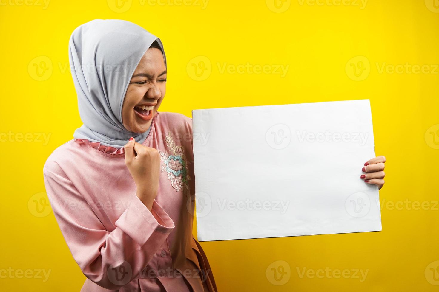 mooie jonge moslimvrouw vrolijk met lege lege banner, plakkaat, wit bord, leeg bord, wit reclamebord, iets presenteren in kopieerruimte, promotie foto