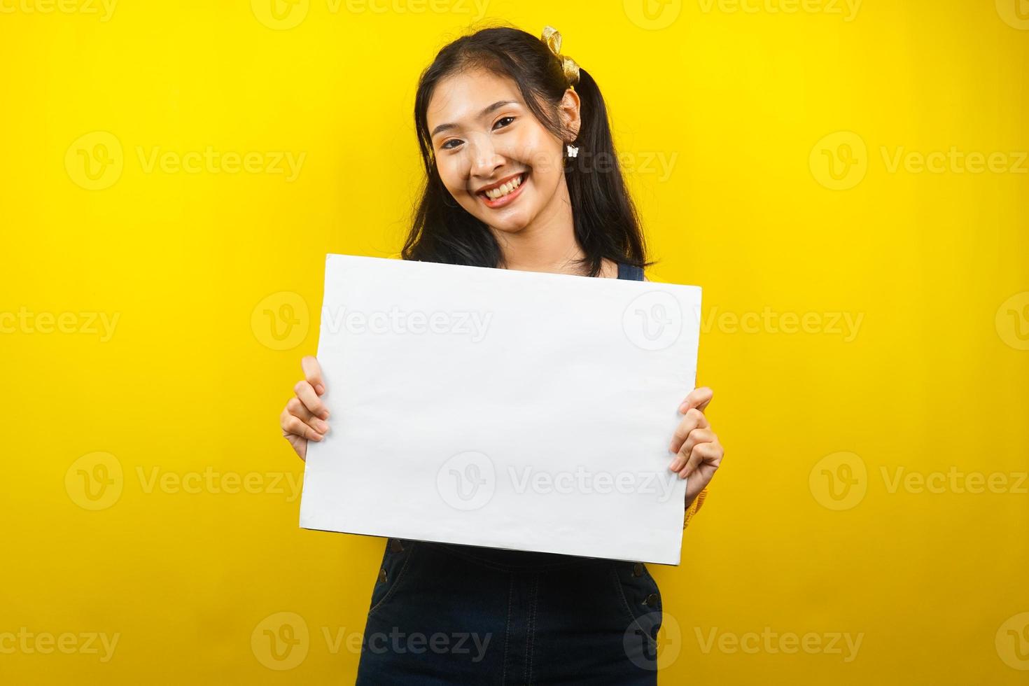 mooie en schattige jonge vrouw vrolijk met lege lege banner, plakkaat, wit bord, leeg bord, wit reclamebord, iets presenteren in kopieerruimte, promotie foto