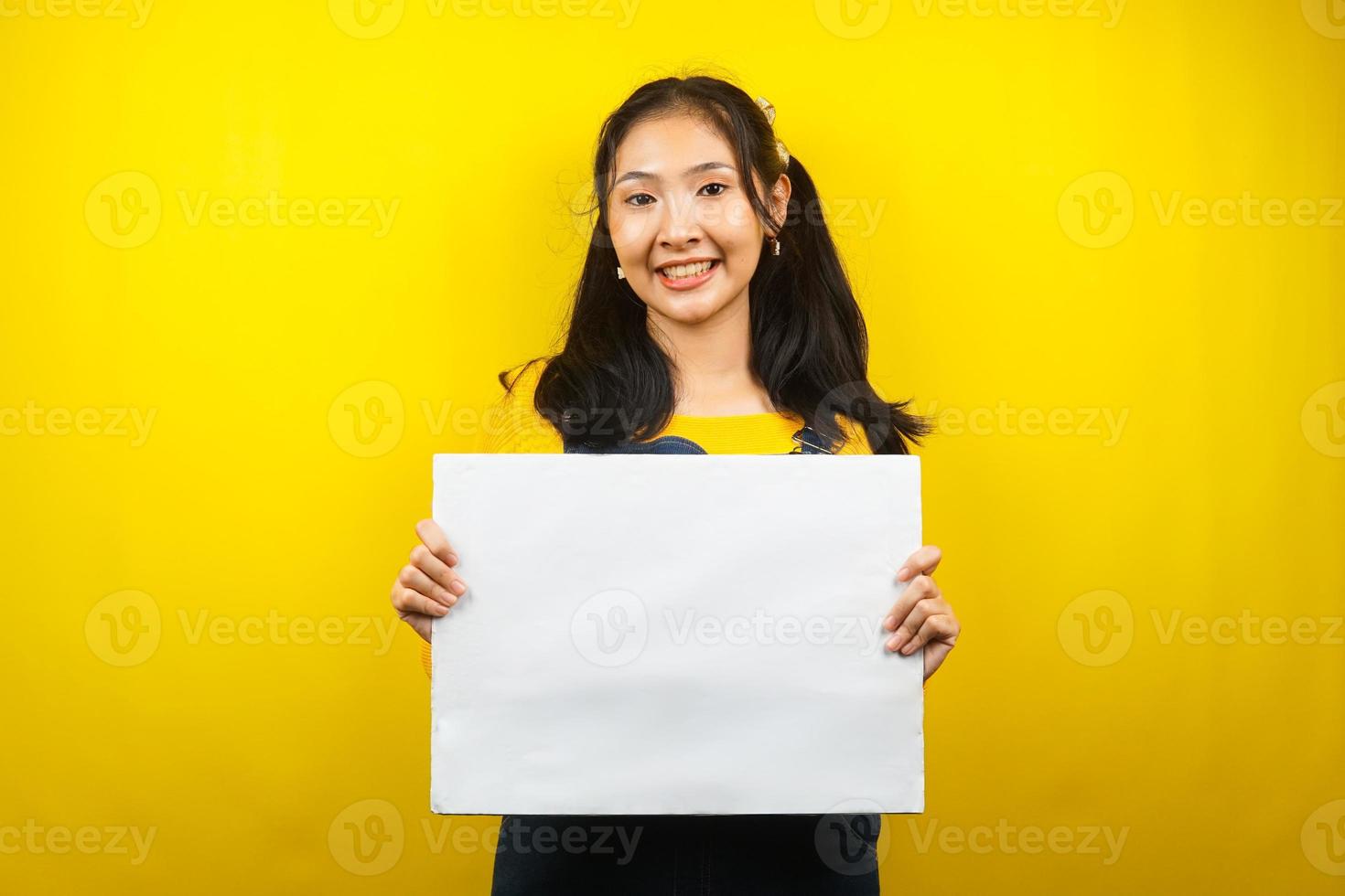 mooie en schattige jonge vrouw vrolijk met lege lege banner, plakkaat, wit bord, leeg bord, wit reclamebord, iets presenteren in kopieerruimte, promotie foto