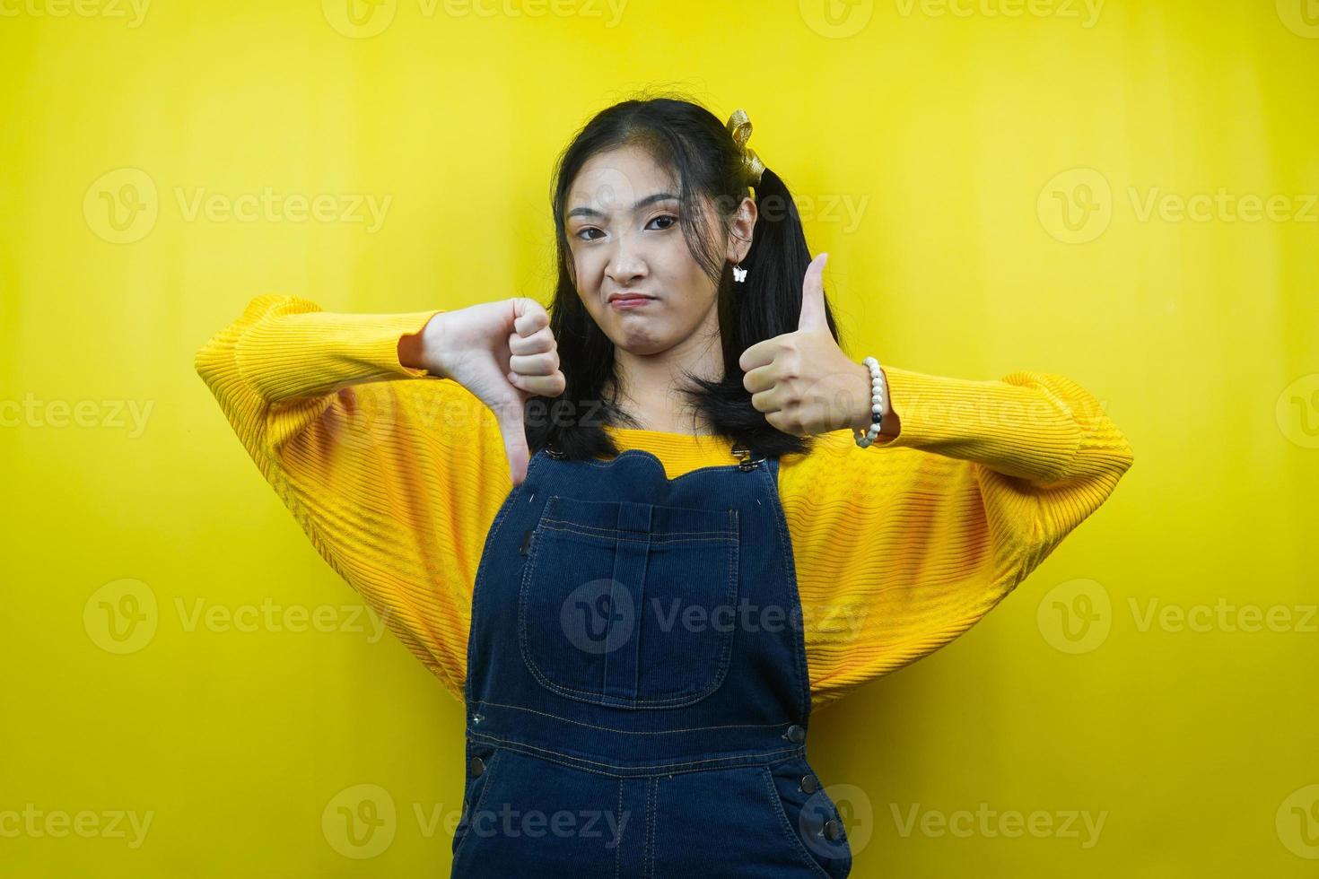 mooie en schattige jonge vrouw met handen leuk of niet leuk, ja of nee, blij of verdrietig, twee dingen vergelijken, reclame, geïsoleerd foto