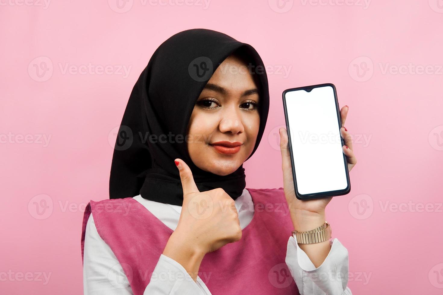 close-up van mooie en vrolijke jonge moslimvrouw met smartphone met wit of leeg scherm, app promoten, iets promoten, geïsoleerd, reclameconcept foto