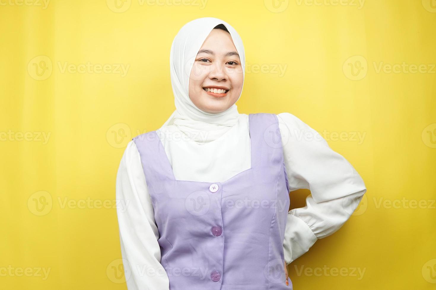 mooie jonge aziatische moslimvrouw die vol vertrouwen lacht, naar de camera kijkt geïsoleerd op gele achtergrond foto