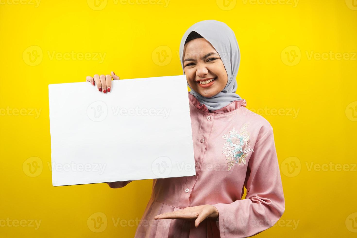 mooie jonge moslimvrouw vrolijk met lege lege banner, plakkaat, wit bord, leeg bord, wit reclamebord, iets presenteren in kopieerruimte, promotie foto