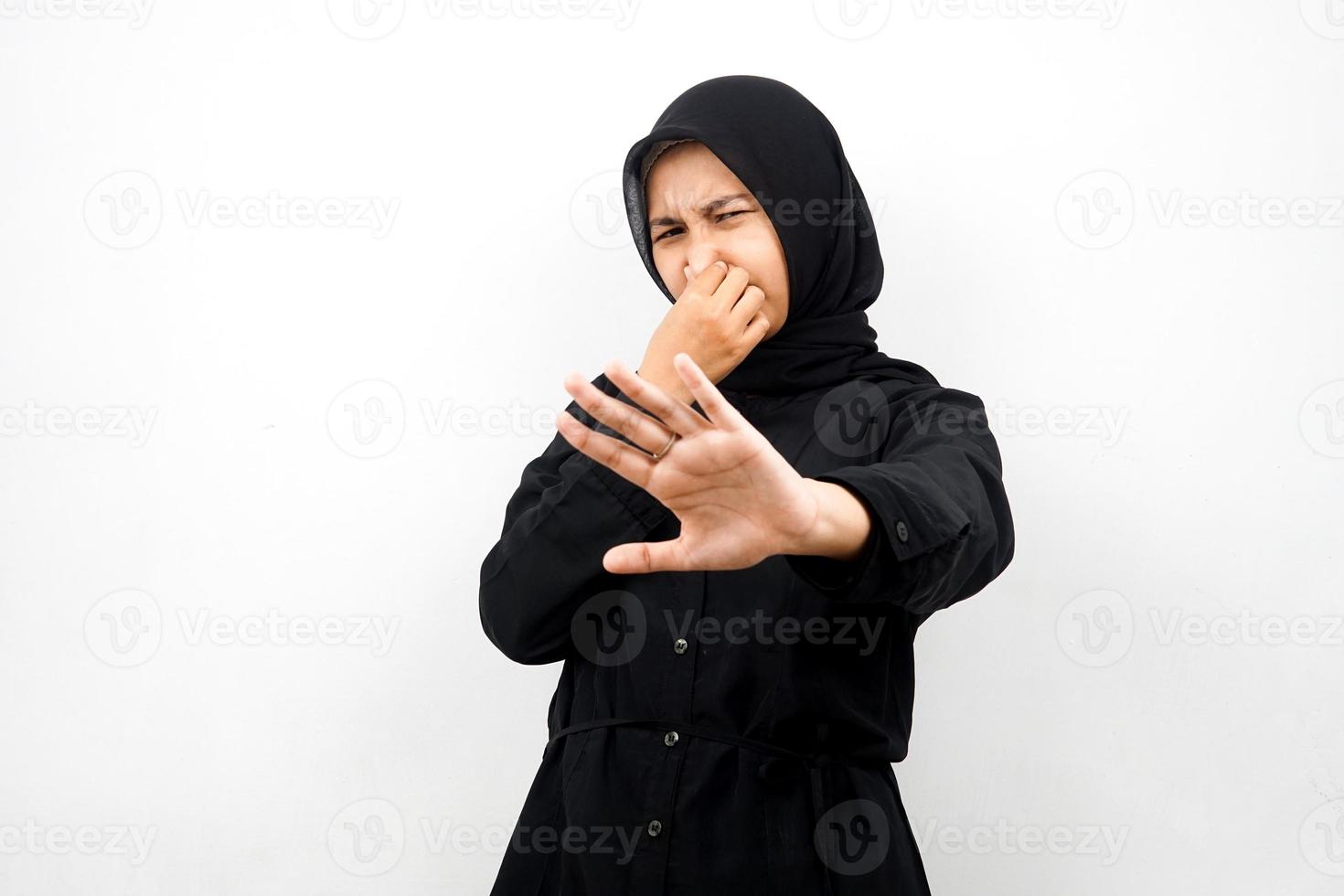 mooie jonge aziatische moslimvrouw met hand die de mond bedekt en iets weigert dat op een witte achtergrond wordt geïsoleerd foto