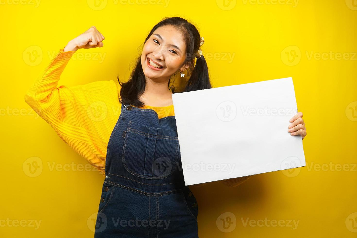 mooie en schattige jonge vrouw vrolijk met lege lege banner, plakkaat, wit bord, leeg bord, wit reclamebord, iets presenteren in kopieerruimte, promotie foto