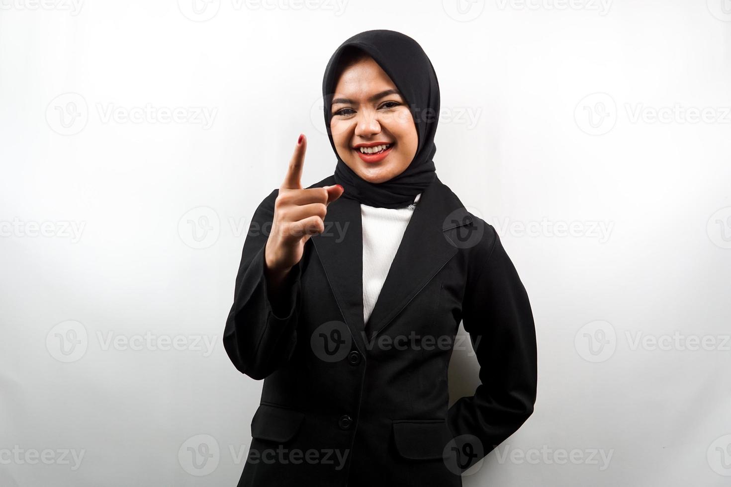 Mooie jonge Aziatische moslim zakenvrouw glimlachend zelfverzekerd en vrolijk, met handen wijzend op camera, wijzend op publiek, wijzend naar klant, geïsoleerd op witte achtergrond foto