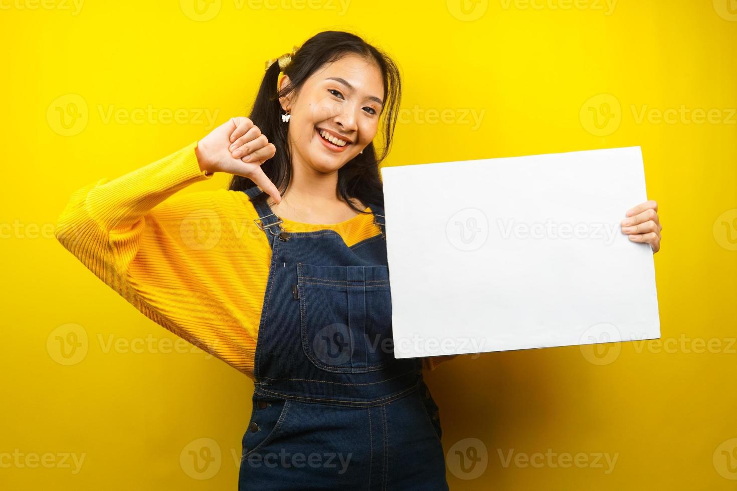 mooie en schattige jonge vrouw vrolijk met lege lege banner, plakkaat, wit bord, leeg bord, wit reclamebord, iets presenteren in kopieerruimte, promotie foto