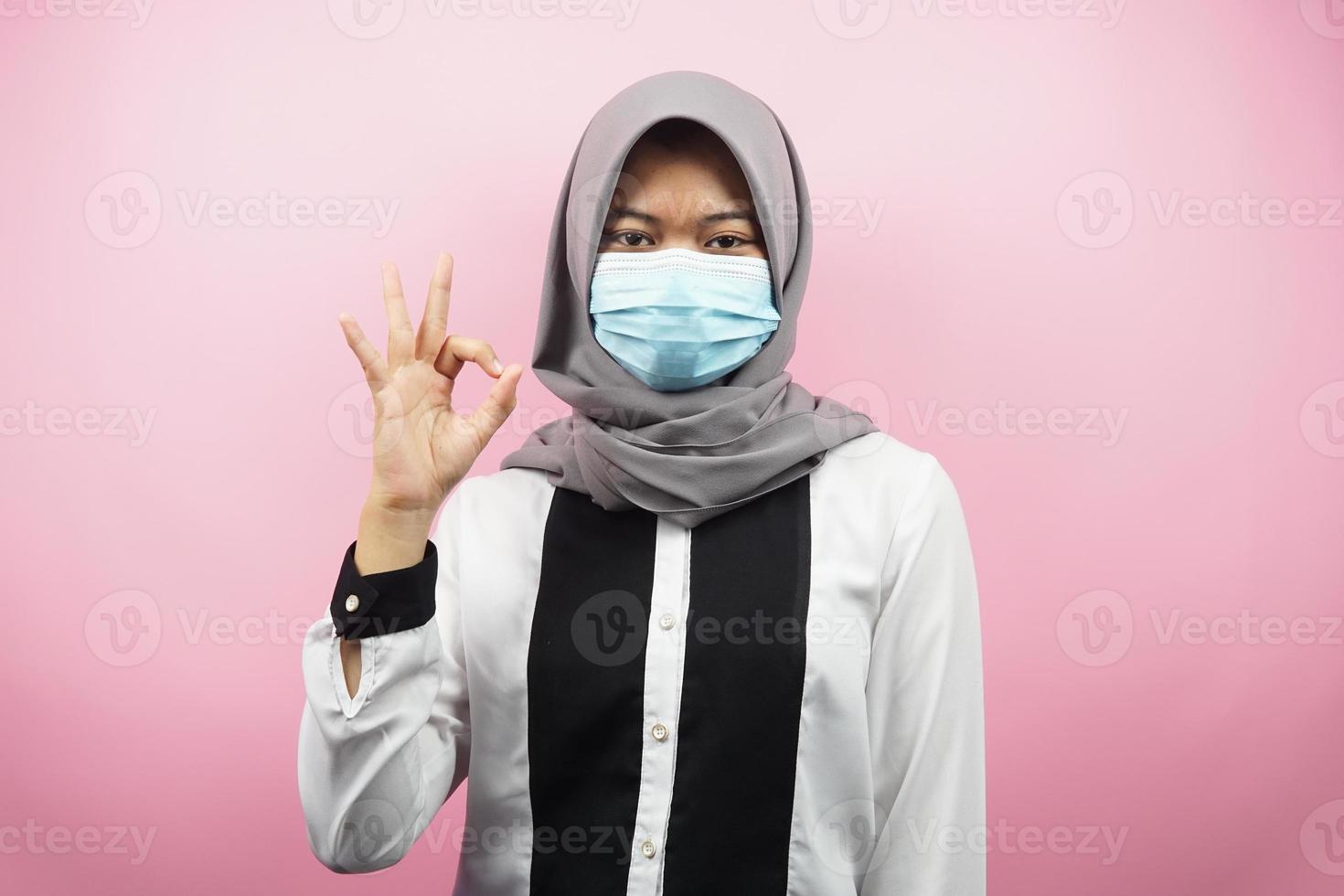 moslimvrouw die medische maskers draagt, anti-coronavirusbeweging, anti-covid-19-beweging, gezondheidsbeweging met maskers, met handen met ok teken, goed werk, succes, overwinning, geïsoleerd foto