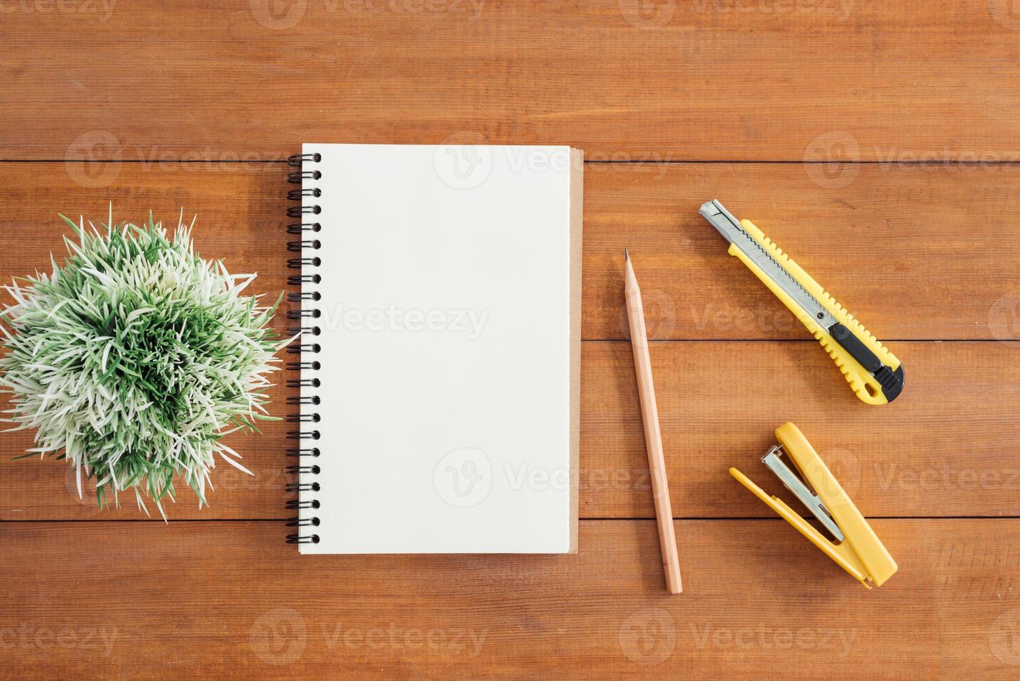 minimale werkruimte - creatieve platliggende foto van werkruimtebureau. Bureau houten tafel achtergrond met open mock-up notebooks en pennen en plant. bovenaanzicht met kopieerruimte, platliggende fotografie.