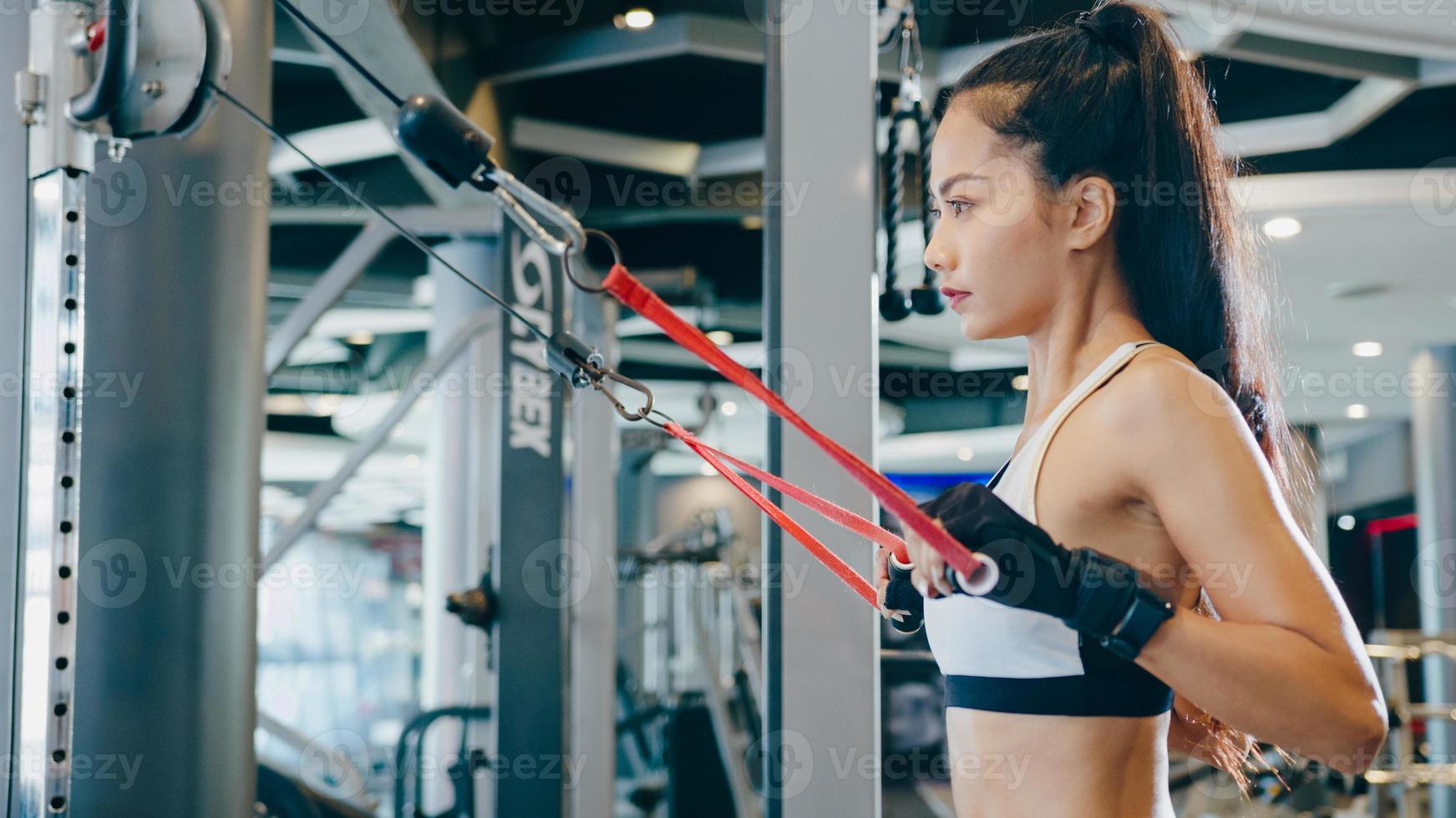 jonge azië dame oefening doen oefening-machine kabel crossover vetverbranding training in fitness klasse. atleet met sixpack, sportvrouw recreatieve activiteit, functionele training, gezonde levensstijl. foto