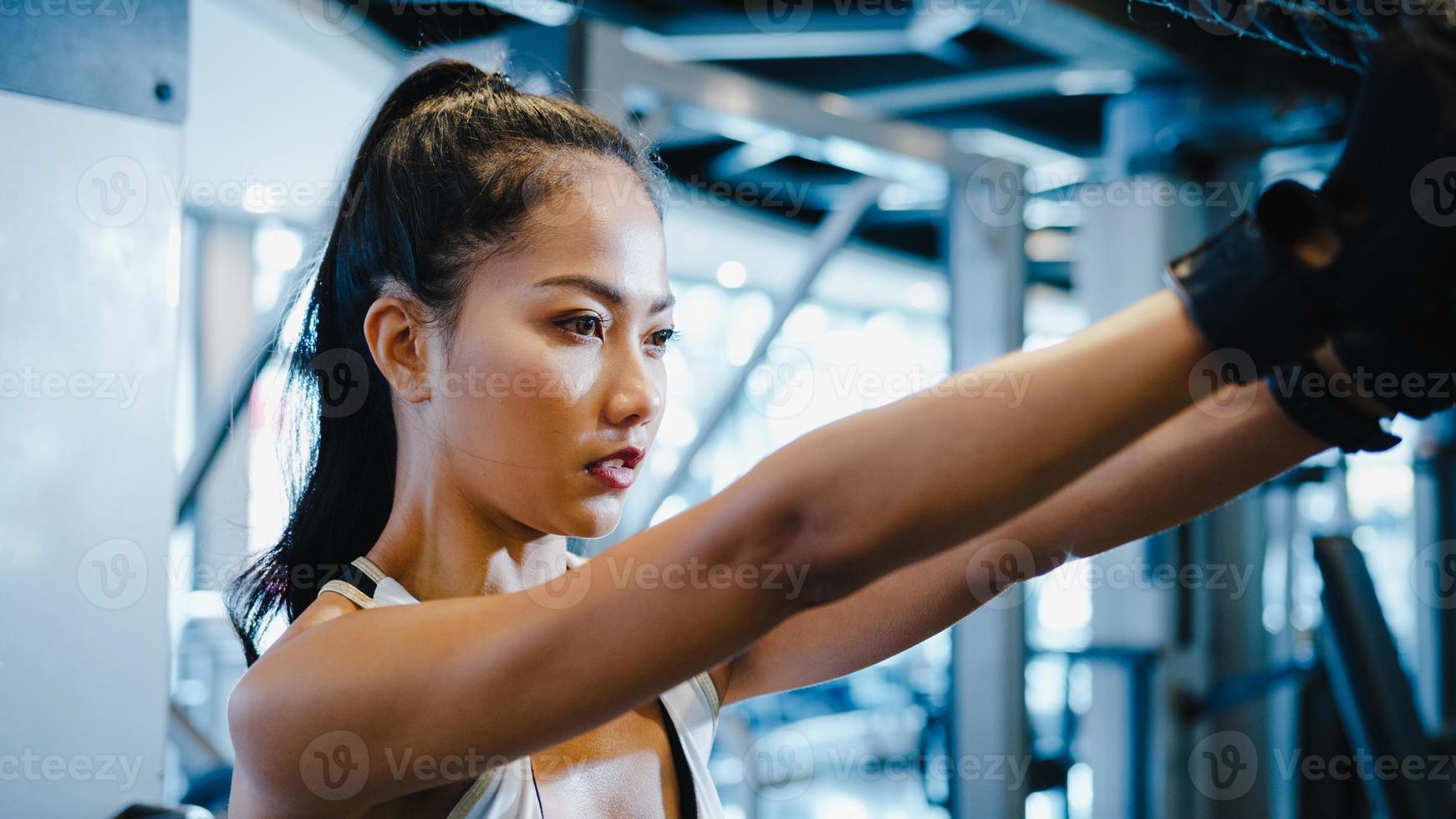 jonge azië dame oefening doen oefening-machine kabel crossover vetverbranding training in fitness klasse. atleet met sixpack, sportvrouw recreatieve activiteit, functionele training, gezonde levensstijl. foto