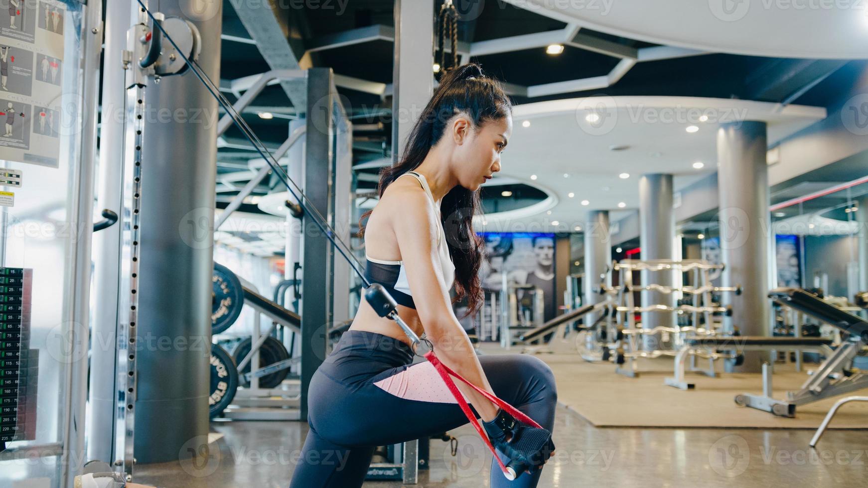 jonge azië dame oefening doen oefening-machine kabel crossover vetverbranding training in fitness klasse. atleet met sixpack, sportvrouw recreatieve activiteit, functionele training, gezonde levensstijl. foto