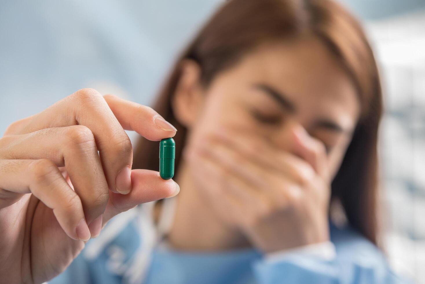 vrouwenhand die een pil vasthoudt, neemt medicijnen in volgens het doktersvoorschrift foto