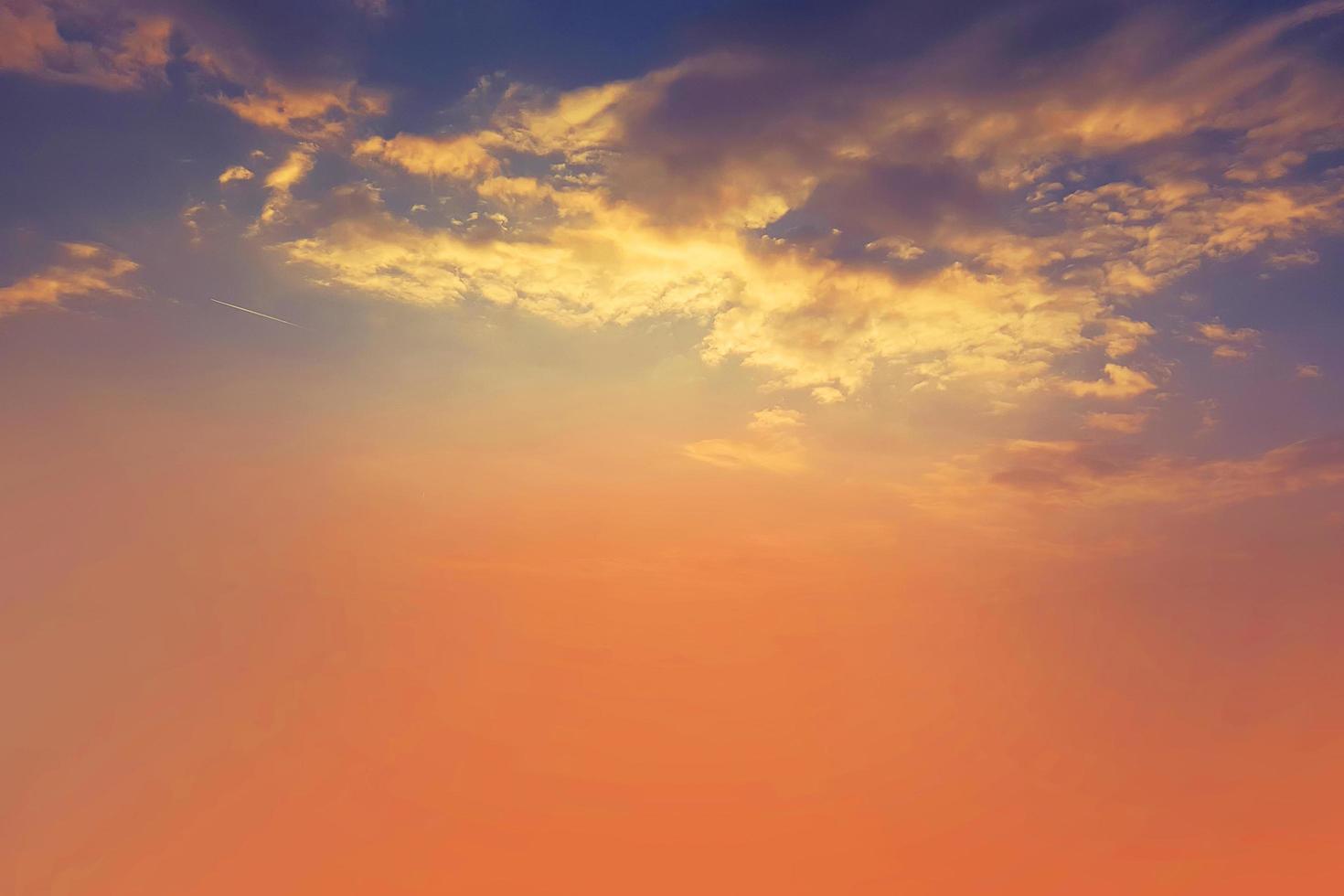 zonsondergang en oranje wolk en blauwe dageraad hemel met wolk horizontale lijnen bewegingseffect op de achtergrond van de zon. foto