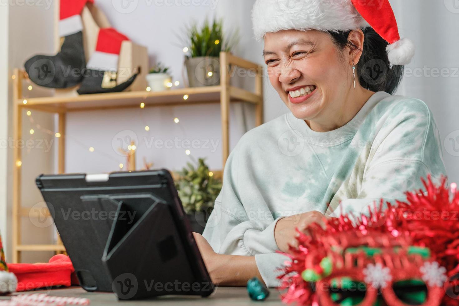 aziatische vrouw viert nieuwjaar en kerstfeest met tablet-videogesprekvrienden thuis foto