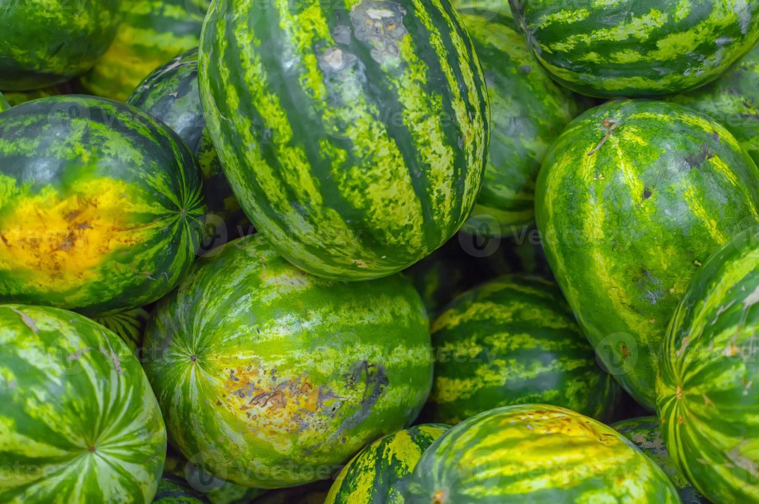 veel verse rijpe watermeloenen liggen in houten kisten in de groente- en fruitafdeling van de supermarkt foto