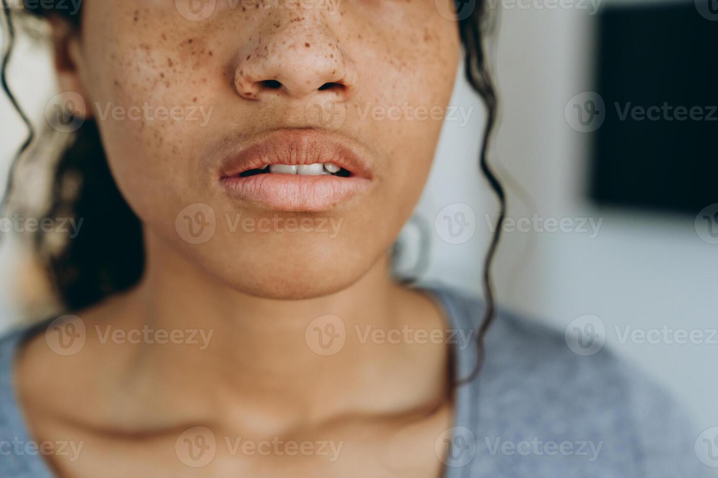 jonge zwarte vrouw die naar de camera kijkt terwijl ze thuis tijd doorbrengt foto