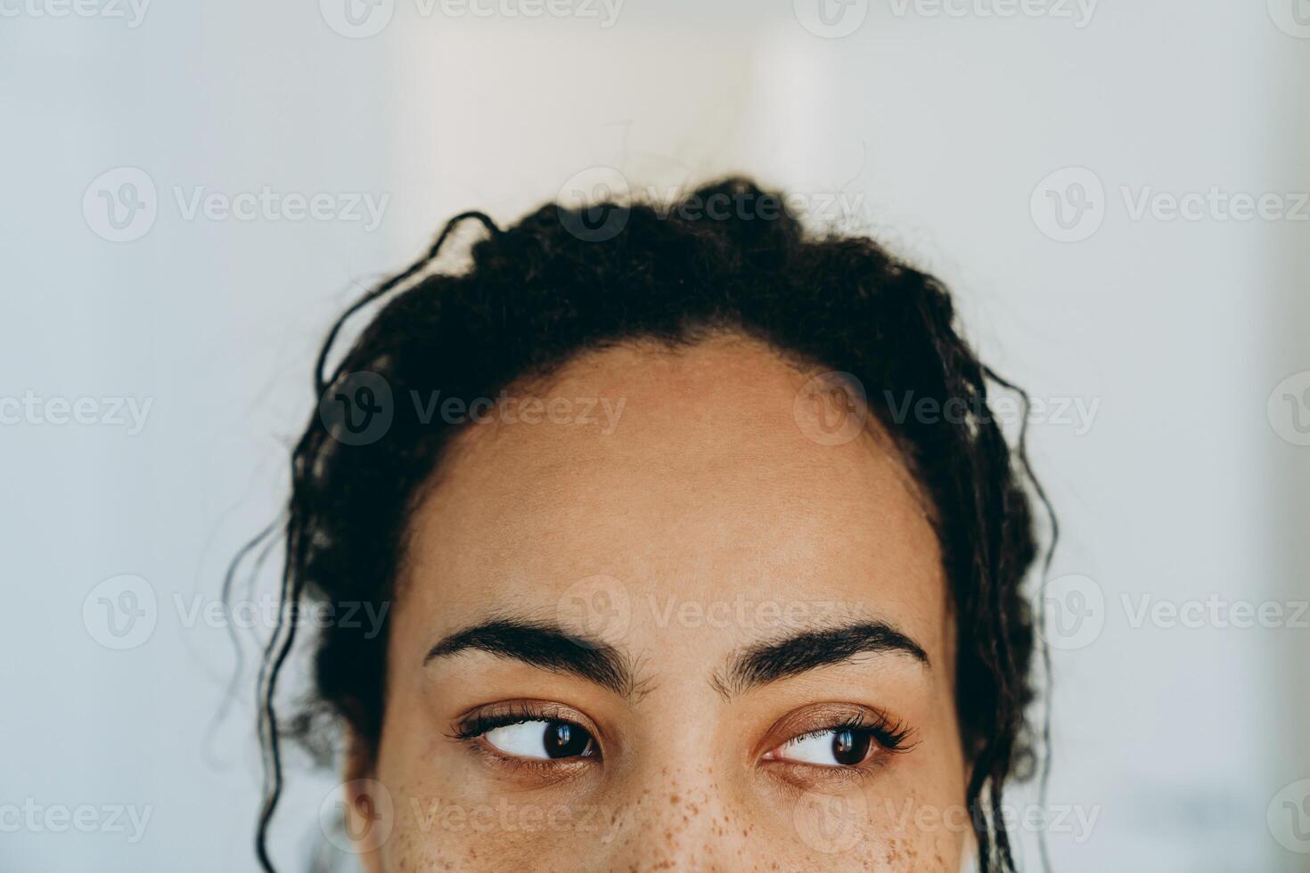 jonge zwarte vrouw die opzij kijkt terwijl ze thuis tijd doorbrengt foto