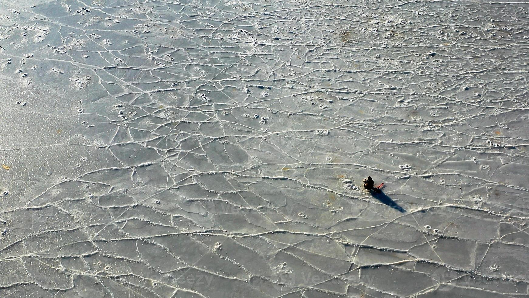 luchtfoto van het ijzige oppervlak van de zee met een visser foto
