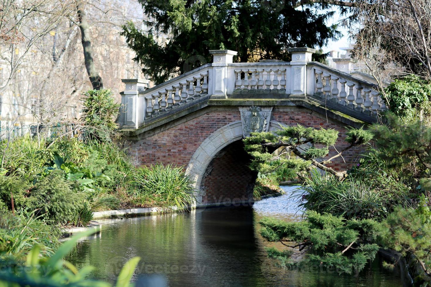 prachtige oude stenen brug met reling over schone rivier in Preserve foto