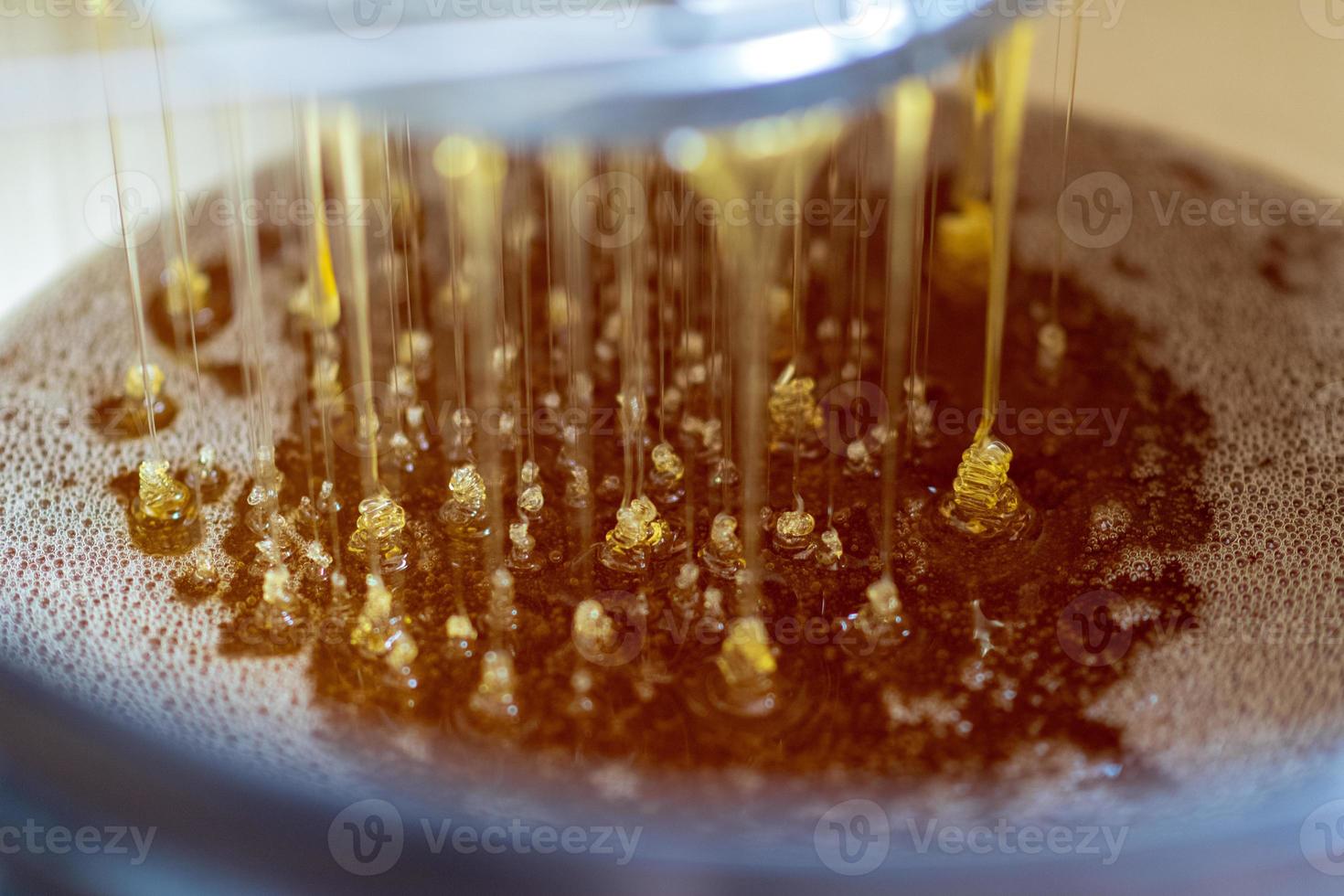 druppel bijenhoningdruppel van zeshoekige honingraten foto