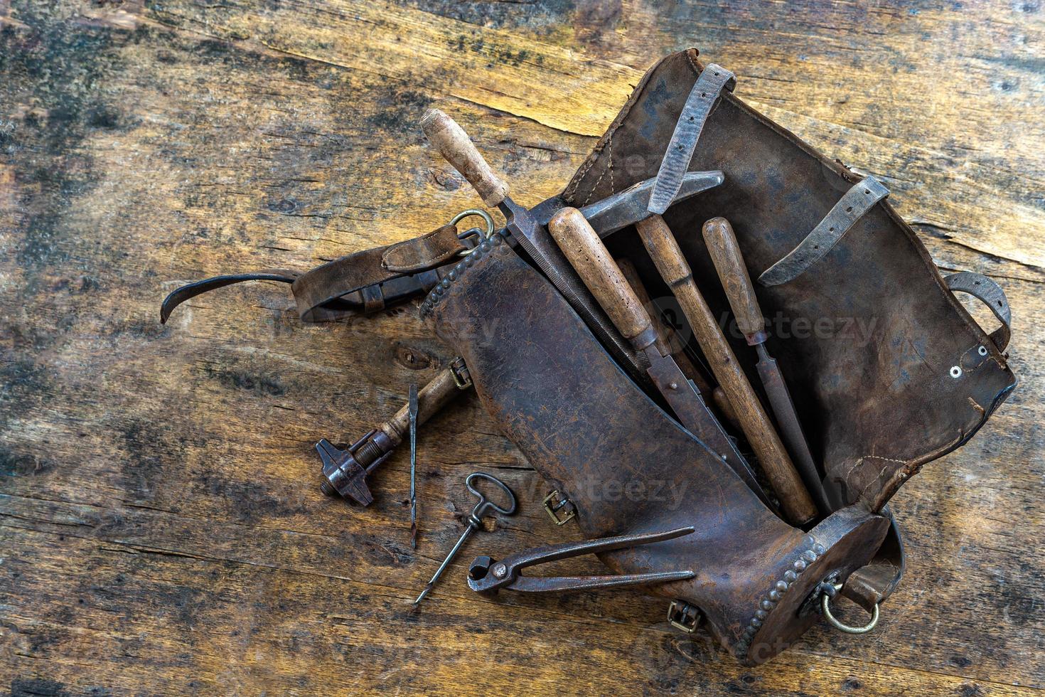 set gereedschap in oude leren tas op de omd houten vloer foto