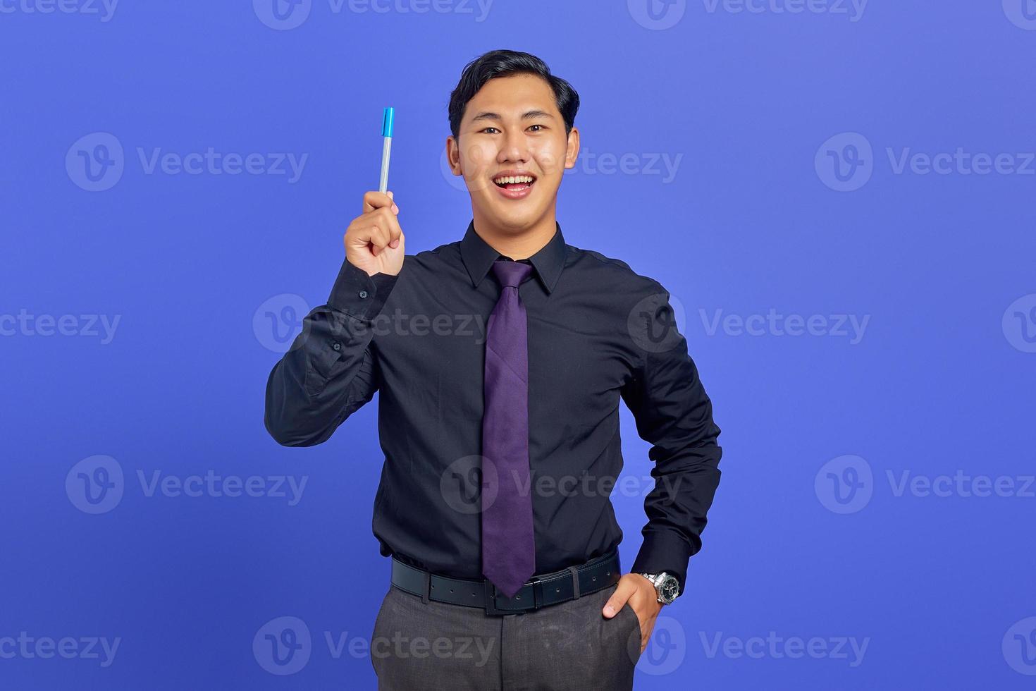 gelukkige jonge knappe zakenman met een creatief idee en camera kijken op paarse achtergrond foto