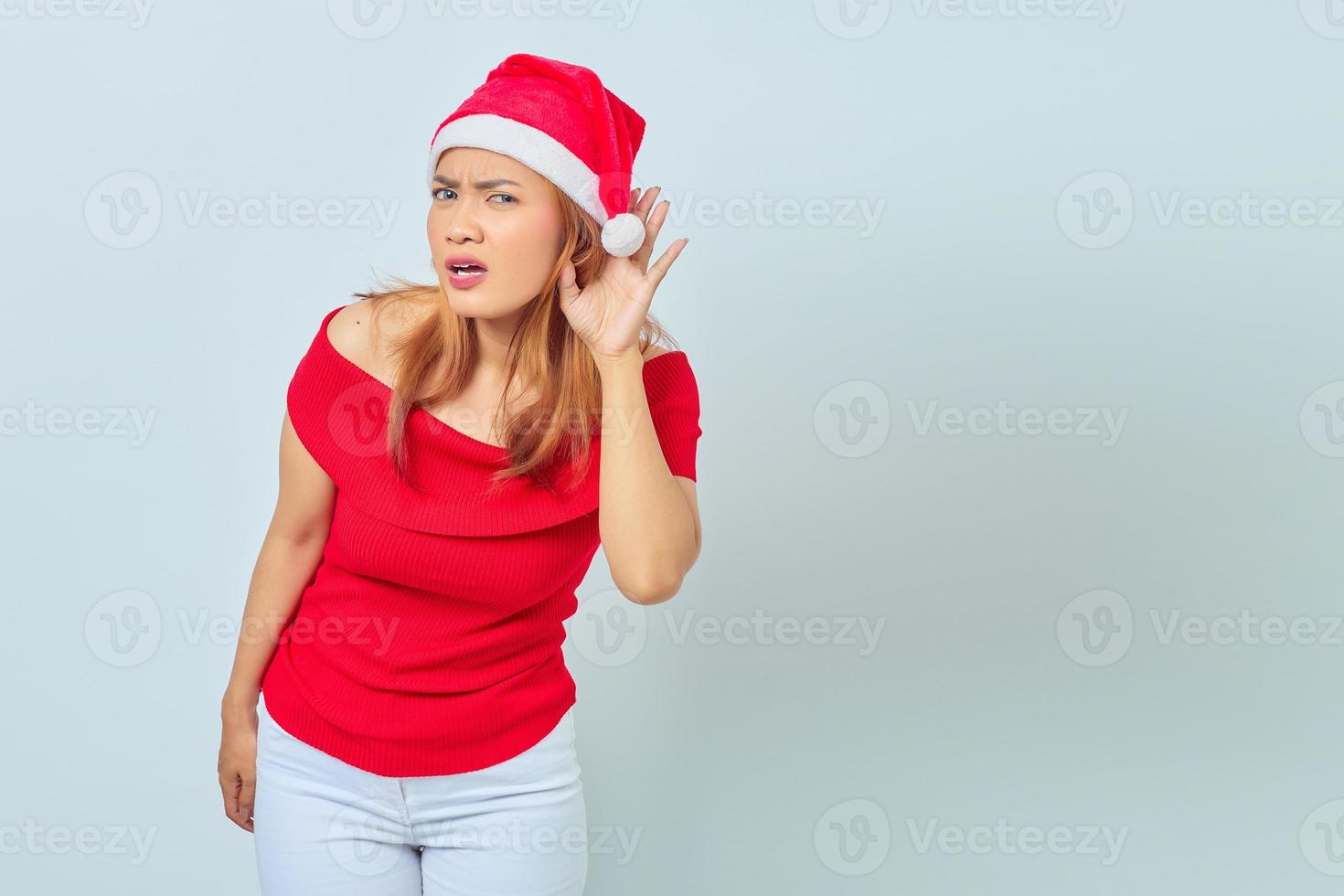 portret van een jonge aziatische vrouw die een kerstjurk draagt en naar een geheim gesprek luistert foto