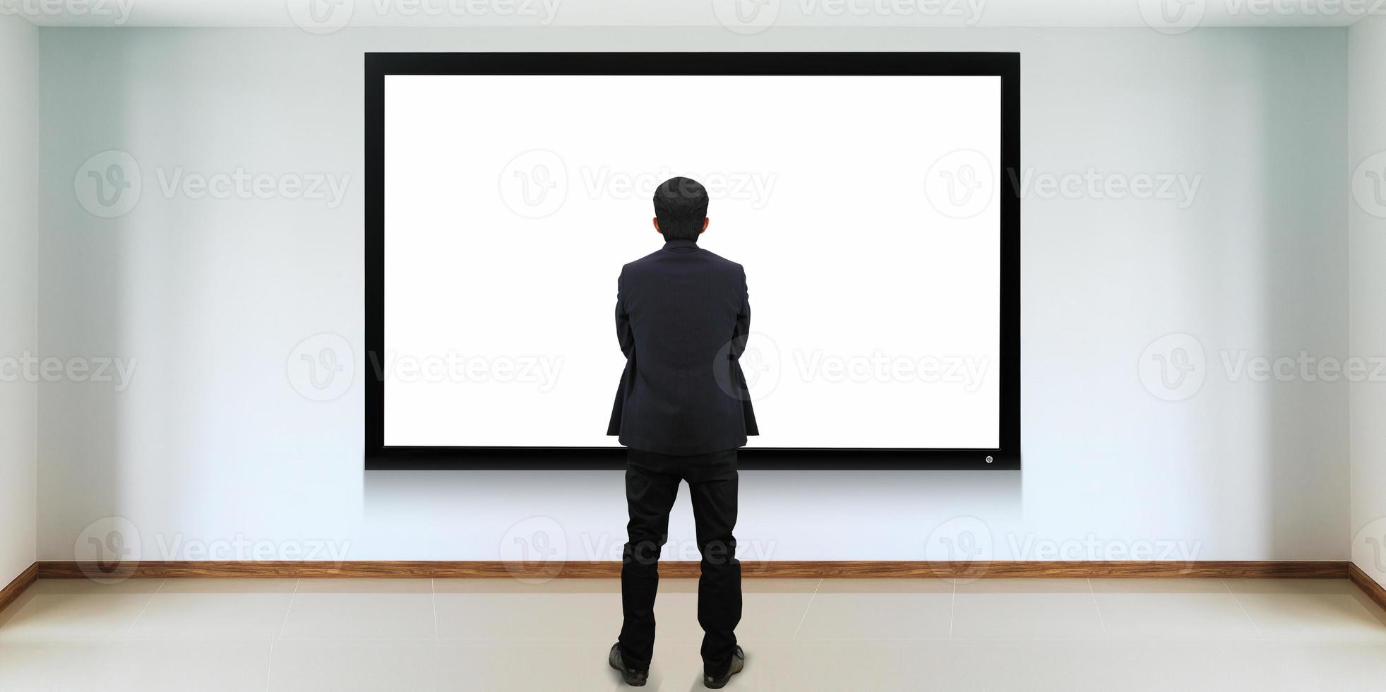 succesvolle zakenman die voor het tv-scherm staat foto