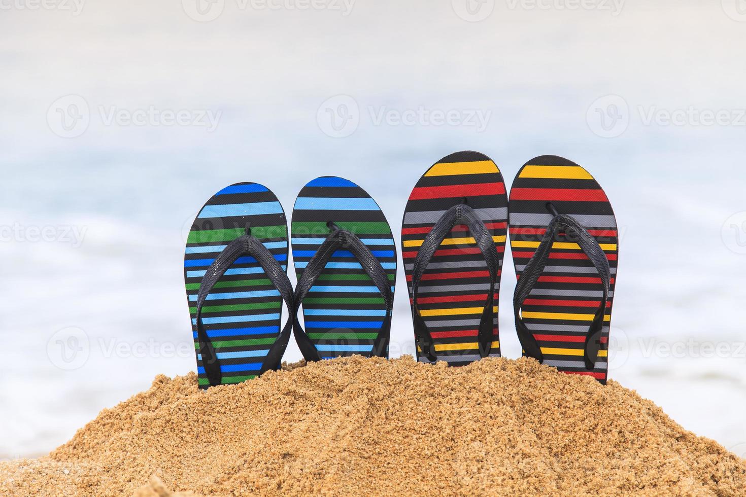 teenslippers op het zandstrand foto