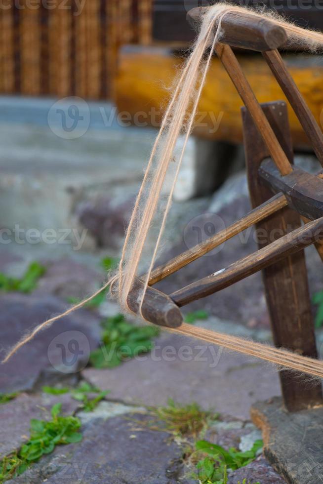 oude wollen spinner op het werk buitenshuis foto