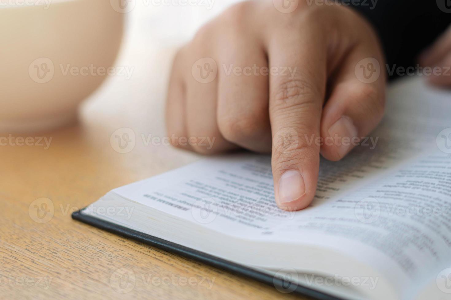 een jonge christelijke vrouw zit op zondag thuis de bijbel te lezen en te bestuderen. met de leer van de heilige profeet foto