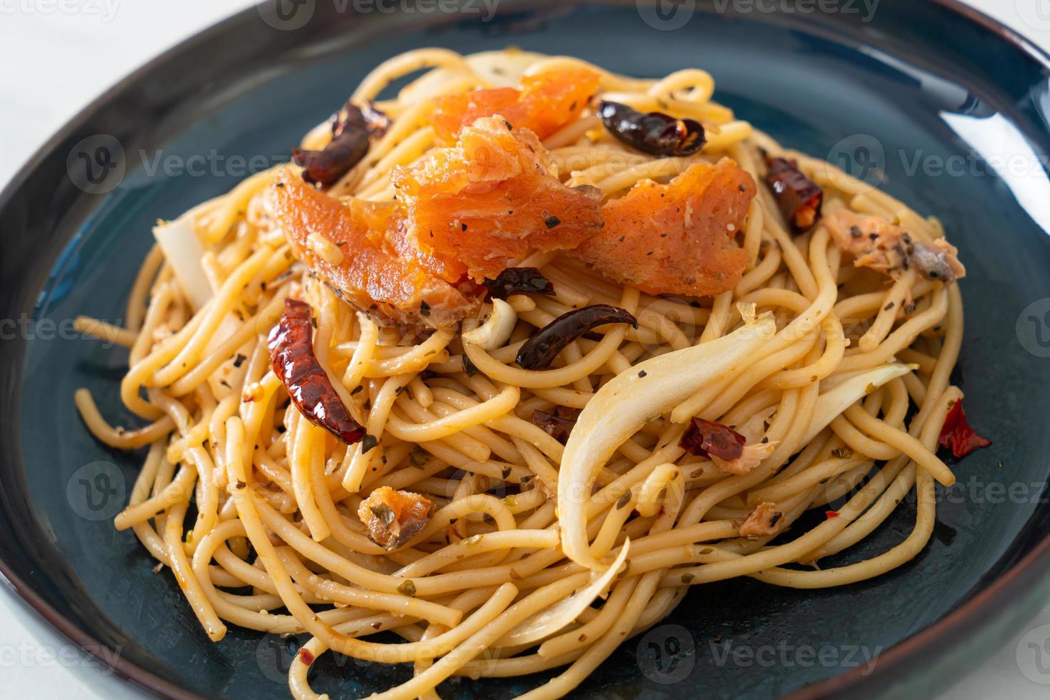 roergebakken spaghetti met zalm en gedroogde chili foto