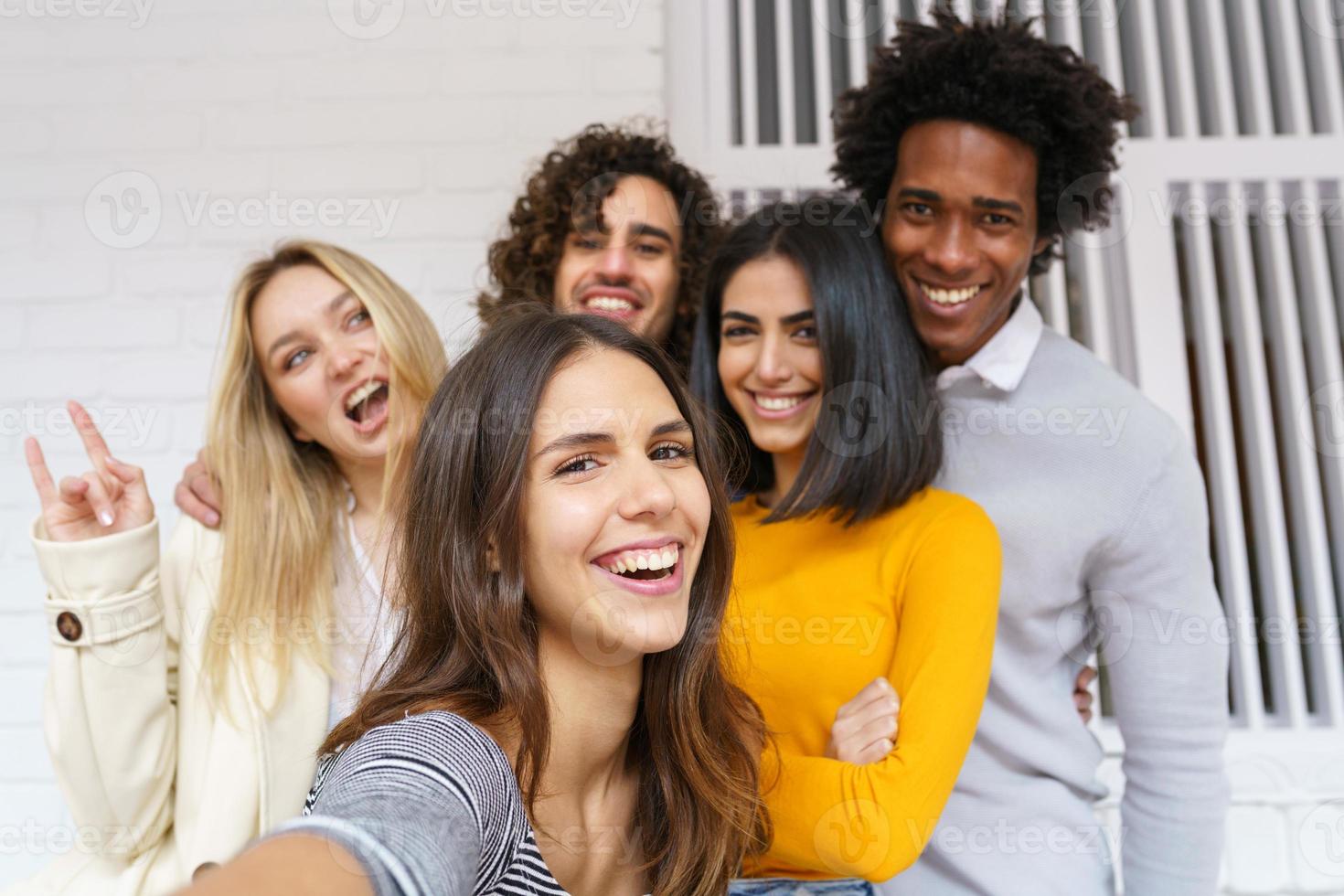 multi-etnische groep vrienden die samen een selfie maken terwijl ze buiten plezier hebben. foto