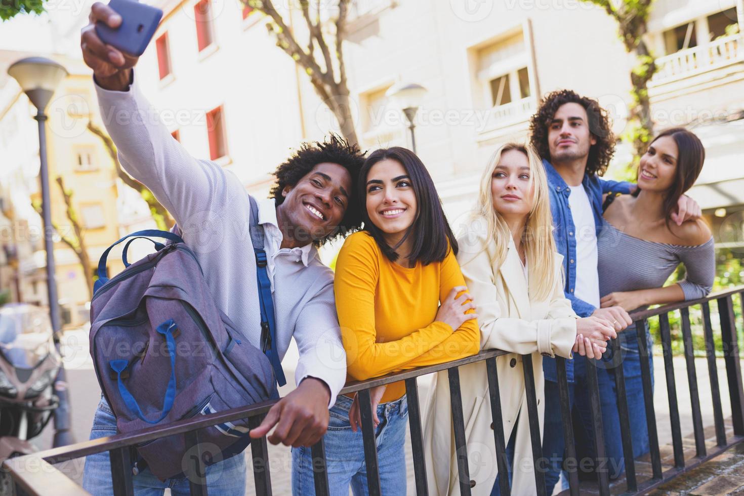 multi-etnische groep vrienden die een selfie op straat maken met een smartphone. foto