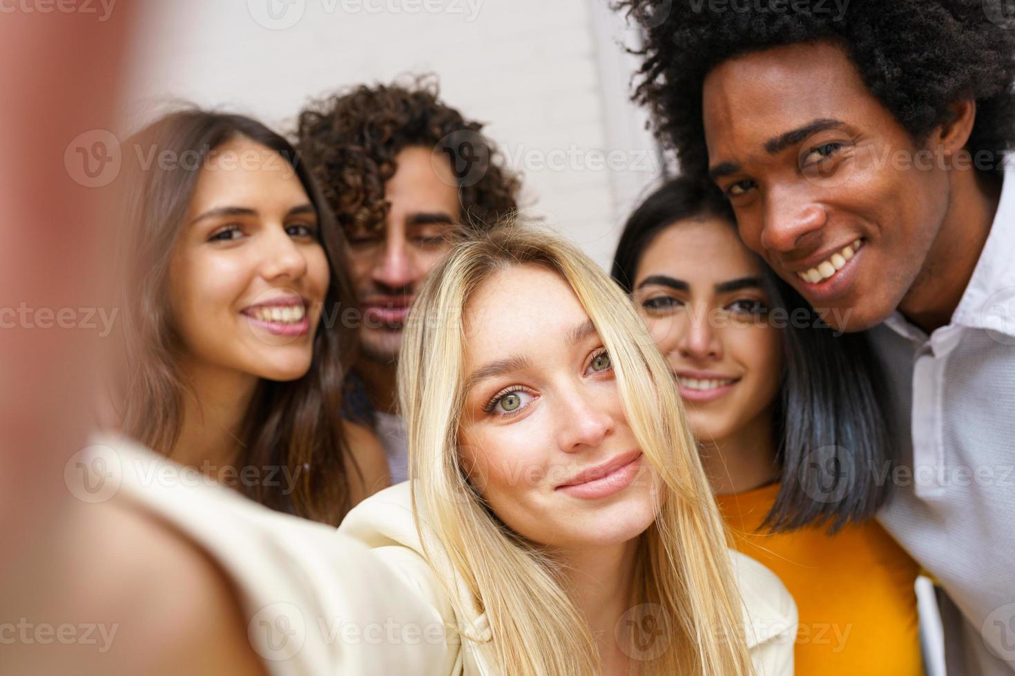 multi-etnische groep vrienden die samen een selfie maken terwijl ze buiten plezier hebben. foto