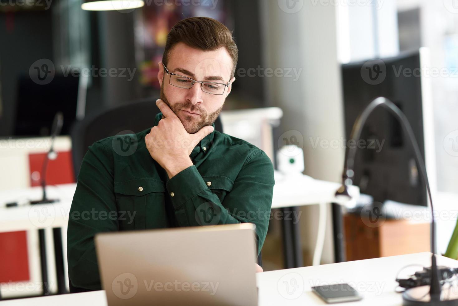 jonge man studeren met laptopcomputer op wit bureau. foto