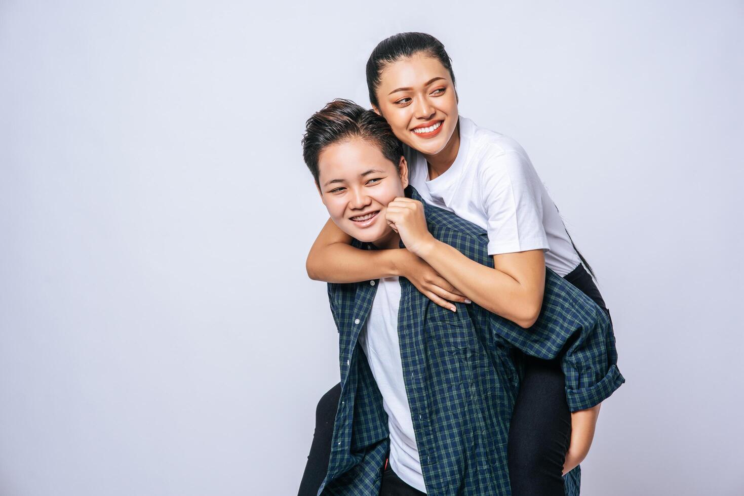 twee liefhebbende vrouwen droegen gestreepte shirts en reden op hun rug. foto