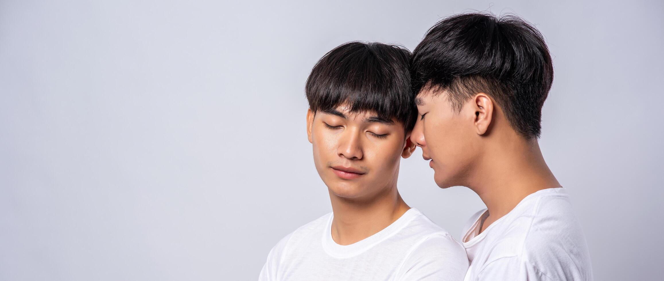 twee verliefde mannen in witte t-shirts keken elkaar aan. foto